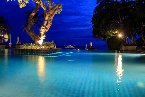 Zwembad in de tropen op het blauwe uur - Foto, afbeelding