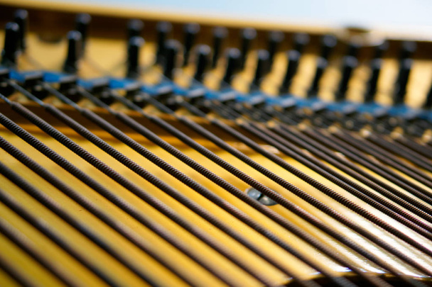 Басові струни натягнуті на старе піаніно. Механізм музичних інструментів. крупним планом
.  - Фото, зображення