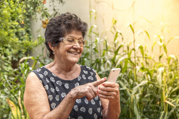 携帯電話を使用して幸せな年配の女性 - 写真・画像