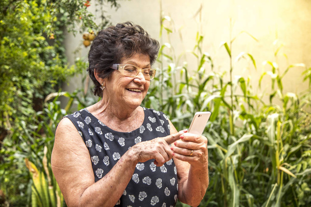 feliz anciana utilizando el teléfono celular
 - Foto, Imagen