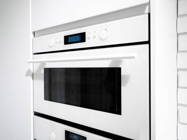 Forno de microondas branco em uma cozinha, estilo interior moderno
. - Foto, Imagem