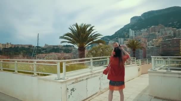 Szczęśliwa matka i dziecko jako turyści, grając w Monte-Carlo z zabytkowym budynku i Palma w tle - Materiał filmowy, wideo