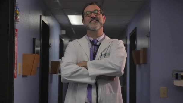 selbstbewusster Arzt, der mit verschränkten Armen auf einem Krankenhausflur steht - Filmmaterial, Video