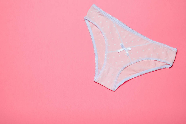 Women's pink cotton panties with polka dots on pink background. Beautiful lingerie. - Photo, Image