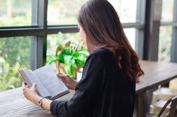 Asiatico donna lettura libro per il tempo di relax in caffè
 - Foto, immagini