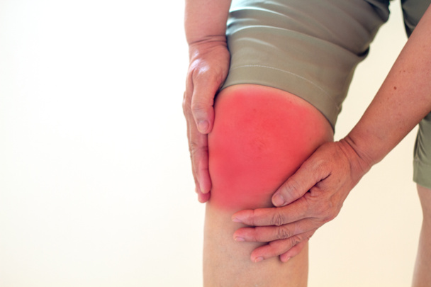 Enfoque suave de las mujeres asiáticas de edad a la lesión de rodilla sobre fondo blanco
 - Foto, imagen