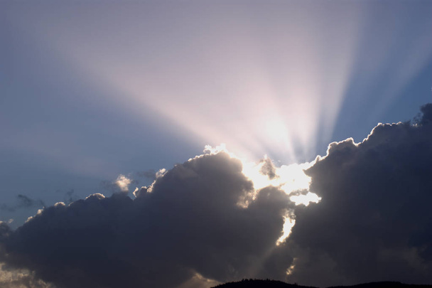 A burst of sunlight through dark clouds. - Фото, изображение