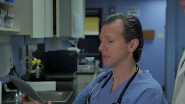 Bir tablet bakarak kadın doktor bir erkek hemşire veya doktor konuşuyor - Video, Çekim