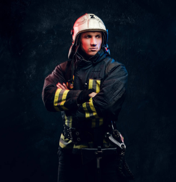 Мужественный пожарный в шлеме смотрит в сторону
 - Фото, изображение