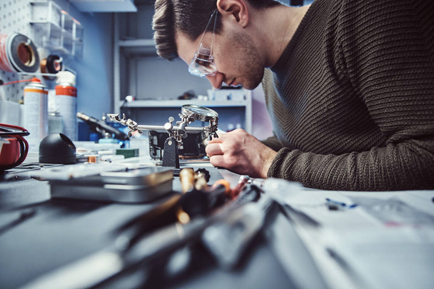 Electronic technician working in the repair shop - Foto, imagen