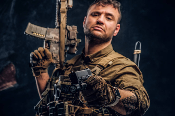 Voják speciálních sil na sobě neprůstřelnou vestu holding útočná puška a zamíření zbraní na kameru. - Fotografie, Obrázek