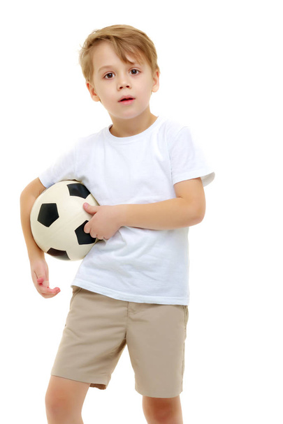 A little boy wearing a pure white t-shirt is playing with a socc - Zdjęcie, obraz