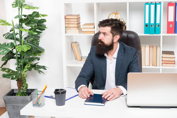 Usual day in office. Man bearded hipster boss sit in leather armchair office interior. Boss at workplace. Manager formal clothing corporate style working. Business people concept. Busy boss in office - 写真・画像