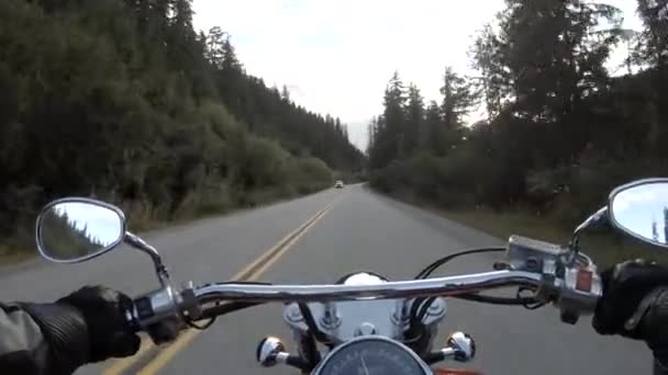 Ajaminen moottoripyörällä kauniilla luonnonkauniilla tiellä, jota ympäröivät Kanadan vuoret. Suur-Vancouver, BC, Kanada
. - Materiaali, video
