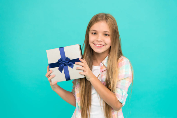 Birthday present. Cute shopper enjoy doing a little shopping. Small girl after shopping for gift. Little shopaholic with present wrapped in box. Small child holding gift box tied with ribbon bow - Foto, Imagen