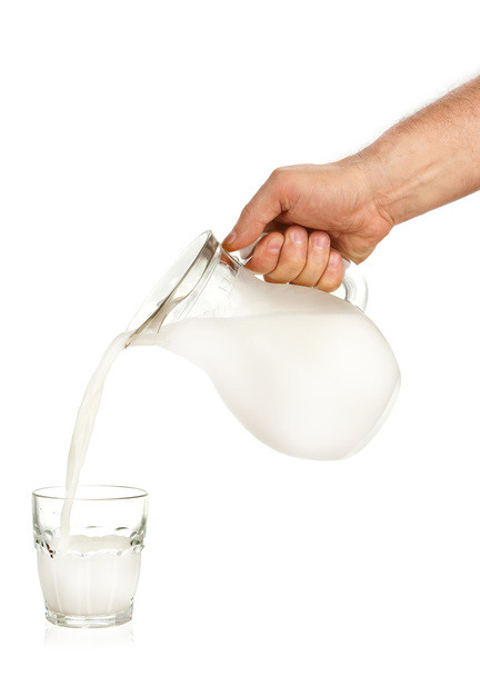 Hand pouring milk from jug to glass - Fotografie, Obrázek