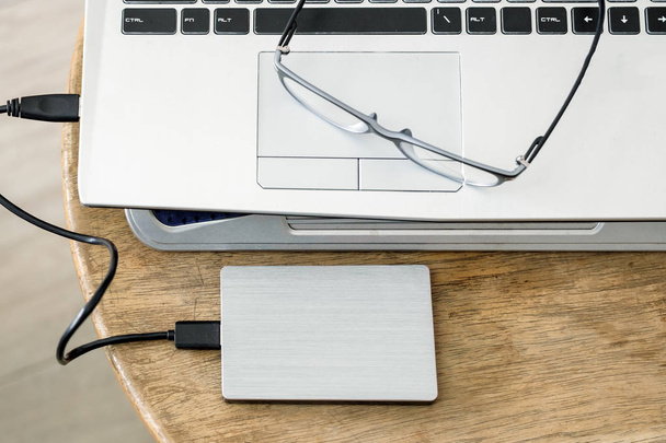 Notebook grey modern black keyboard with hdd grey and spectacles - 写真・画像