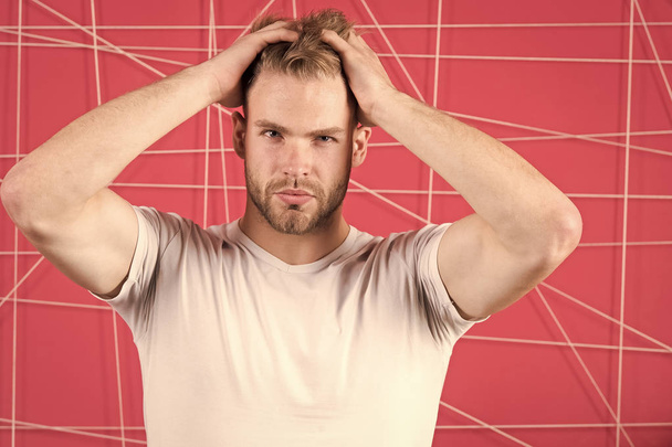 Man with bristle strict face enjoy freshness of hair, pink background. Haircare concept. Man with beard or unshaven guy handsome and well groomed touching hair. Guy bearded attractive with hairstyle - Foto, immagini