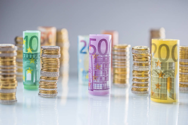 Rolled euro banknotes and coins towers stacked in other positions - Foto, Bild