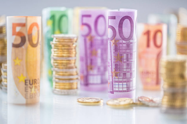 Rolled euro banknotes and coins towers stacked in other positions - Фото, изображение