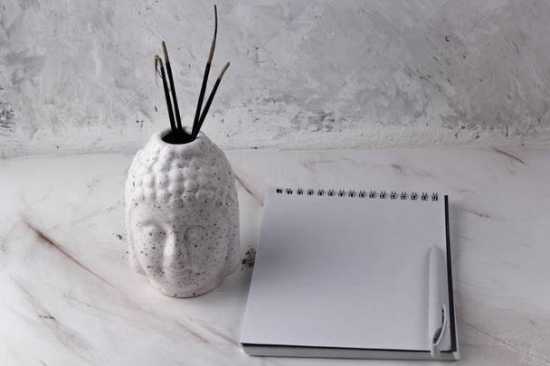 Buddha head with incense  on a marble background - Foto, imagen