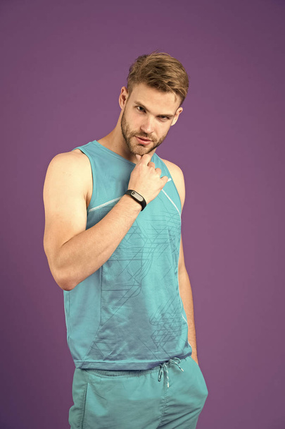 Confident in his fitness regime. Man sporty outfit looks confident and motivated for training, violet background. Stay motivated and achieve sport goal. Motivation is clue for regular sport trainings - Фото, зображення