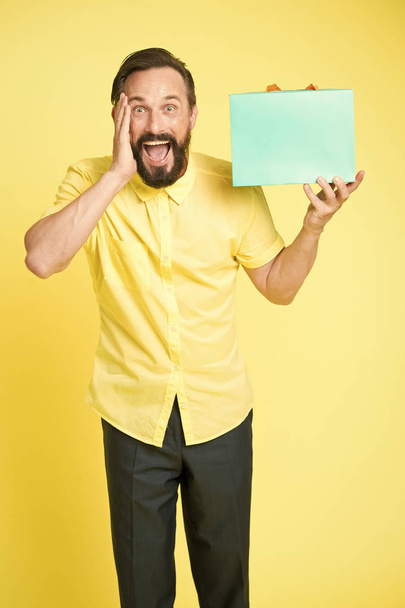 What a surprise. Man mature bearded guy surprised face holds gift box. Man got unexpectable gift. Guy surprised by gift, yellow background. Presents make our lives more interesting - Photo, image