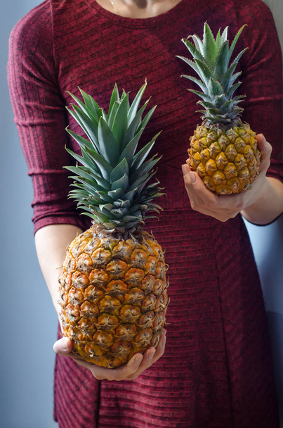Young woman holding two pineapples - Φωτογραφία, εικόνα