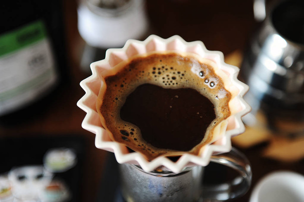 Альтернативна ручна кава для приготування кави в рожевій керамічній крапельниці орігамі з паперовим фільтром. Крупним планом, вид зверху
 - Фото, зображення