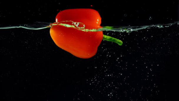 poivron orange vif plongeant dans l'eau claire sur fond noir
  - Séquence, vidéo