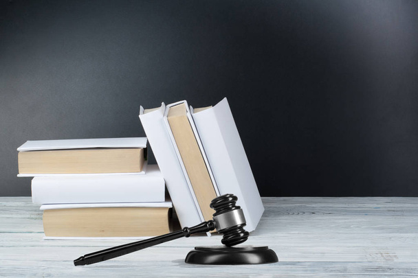 Law concept - Open law book with a wooden judges gavel on table in a courtroom or law enforcement office on blue background. Copy space for text - Φωτογραφία, εικόνα