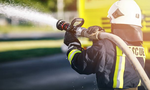 Rescue Firefighter man battle a wildfire. Firefighter in uniform and  helmet. - Фото, изображение