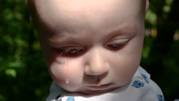 Upset baby in slow motion rises his head with tear on the face. - Footage, Video