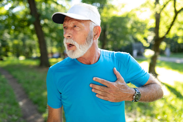 Man with chest pain suffering from heart attack during running - 写真・画像