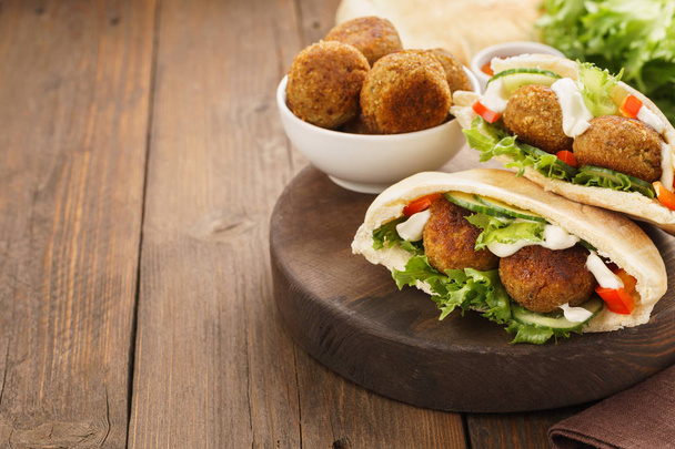 Falafel and fresh vegetables in pita bread with sauce. - Foto, Imagen