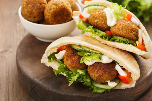 Falafel and fresh vegetables in pita bread with sauce. - Foto, Bild