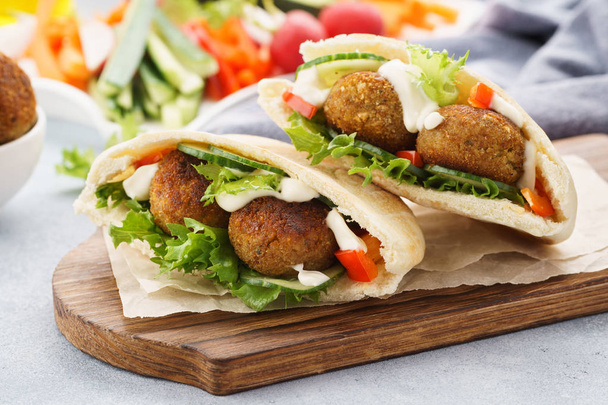 Healthy vegetarian falafel pita with fresh vegetables and sauce - 写真・画像