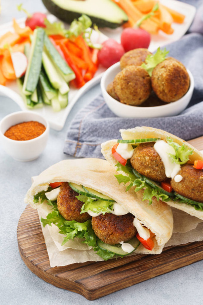 Healthy vegetarian falafel pita with fresh vegetables and sauce - Foto, afbeelding