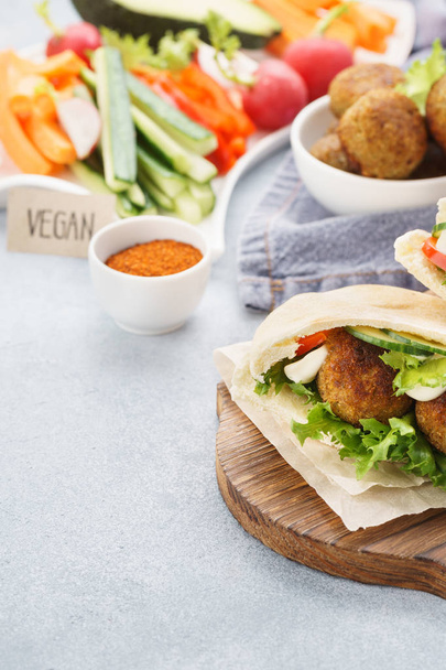 Pita breads with falafel, fresh vegetable sticks and sauce. - Photo, image