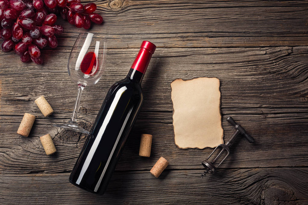 Cena de vacaciones con vino tinto y regalo en madera rústica. Vista superior con espacio para tus saludos
. - Foto, Imagen