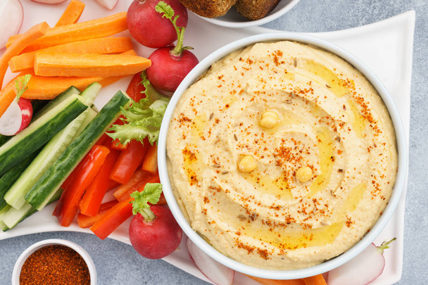 Hummus dip served with fresh vegetable sticks and falafel. - Foto, Bild