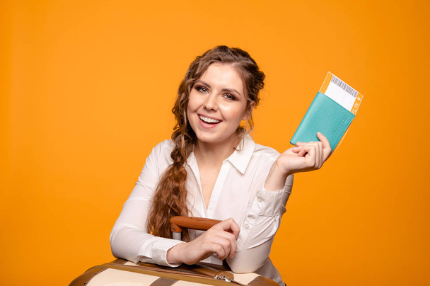 Portrait of nice smiling woman holding passport and flying tickets - Foto, Bild