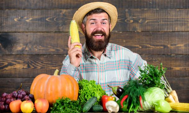 Farmer with organic homegrown vegetables. Grow organic crops. Community gardens and farms. Healthy lifestyle. Homegrown organic food. Man with beard wooden background. Become organic farmer - Фото, зображення