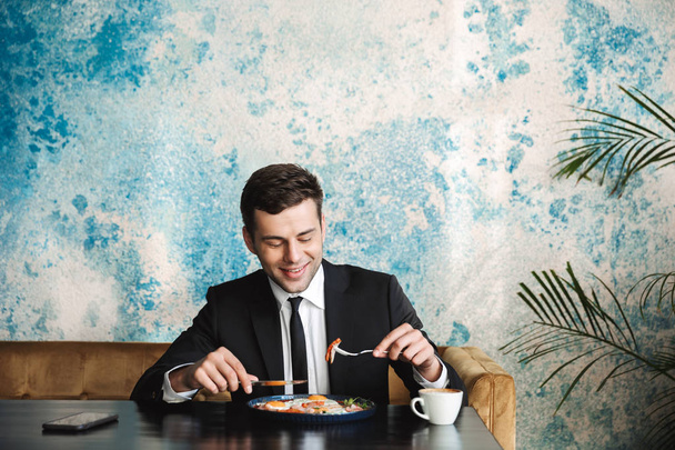 Handsome young businessman sitting in cafe have a breakfast or dinner eat. - Photo, Image