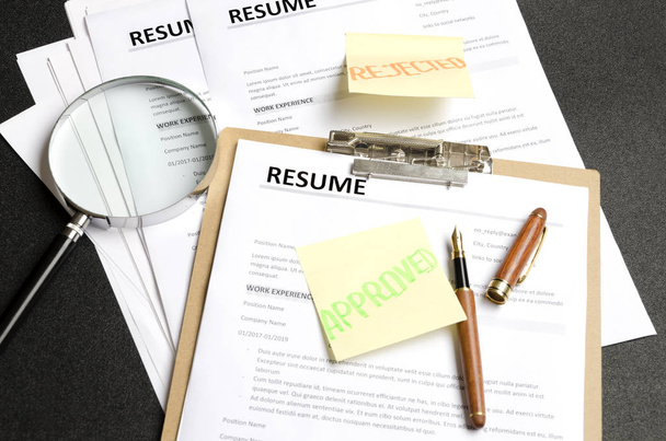Lot of resume templates on black background.Recruiter making decision. Concept of reviewing resume applications - Foto, Imagem