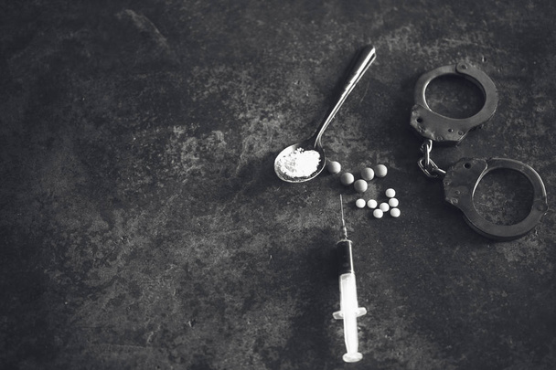 Gyógyszer, fecskendő és főtt heroin a kanál és a bilincs. Koncepció  - Fotó, kép