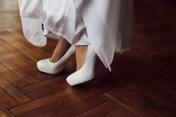 Bridal wedding shoes. Beautiful white shoes on high heels. Women legs - Foto, Imagem