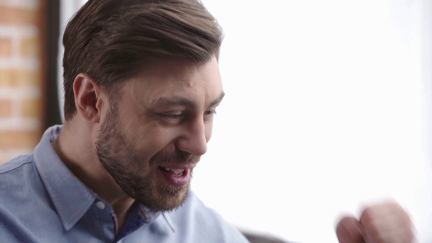 Homme d'affaires concentré en chemise utilisant un ordinateur portable, riant et agitant les poings sur le lieu de travail
 - Séquence, vidéo
