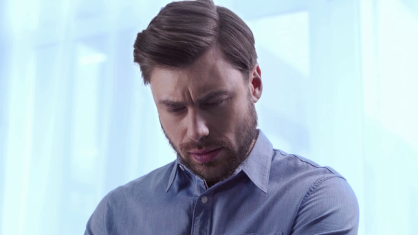Hombre de negocios concentrado con barba parpadeando y mirando hacia abajo mientras usa la tableta digital
 - Metraje, vídeo