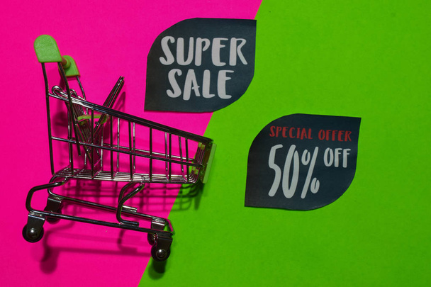 Super Sale and Special Offer 50% Off Text and Shopping cart. Discount and promotion business concept on colorful background - Fotografie, Obrázek